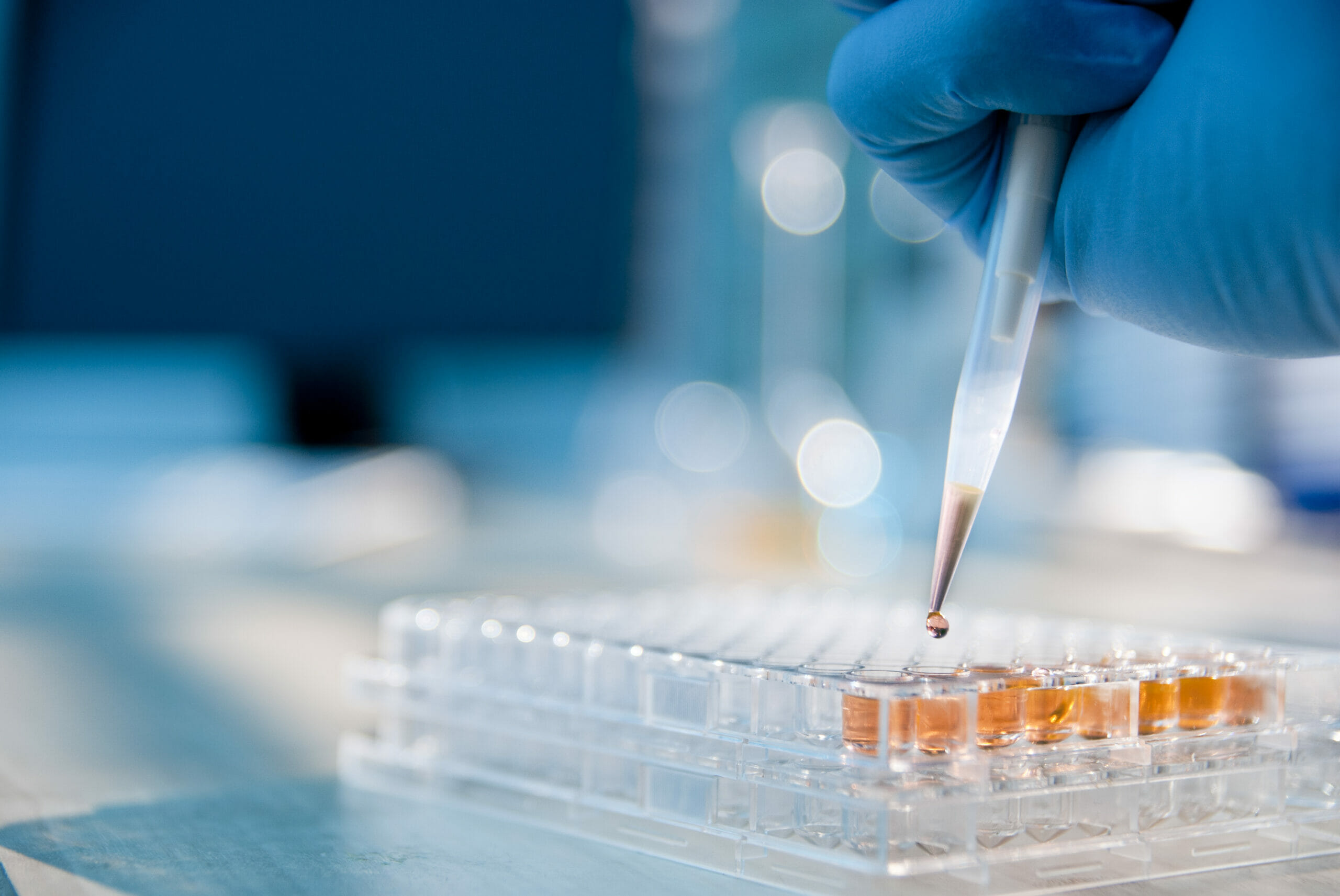 life sciences image, Lab technician injecting liquid into a microtiter plate